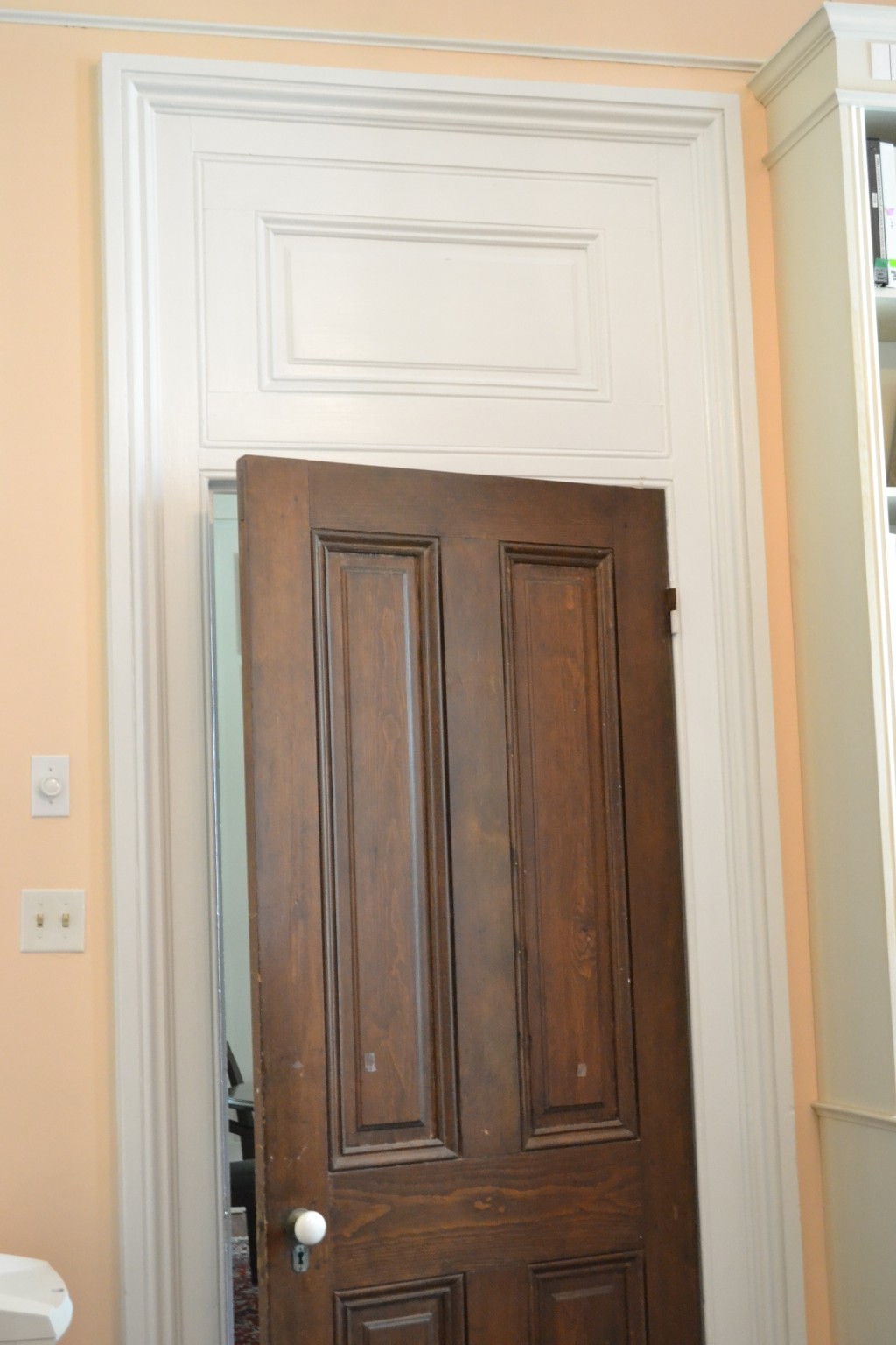 Beautifully paneled, solid wood doors throughout the interior. I love the transom detailing above.